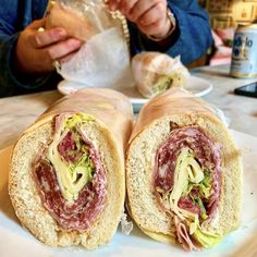 a person sitting at a table with a sandwich in front of them on a plate