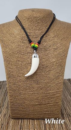 "Resin Tusk necklace, faux imitation tusk, handmade Resin Tusk Pendant. Unisex Necklace with adjustable Black Cord and rasta wooden beads. Powerful Meaning of the Tusk Necklace: It Symbolizes supernatural power, wisdom, strength, and hidden knowledge. Dimensions: Pendant: 2\" Inches Long Adjustable Necklace With Sliding knots. Adjust from 14\" Inches up to 28\" Inches Around the Neck. Wear it as a Choker or Long Necklace. FAST SHIPPING! Visit my Etsy Shop to see more Designs! Handmade Bracelets, Adjustable Long Amulet Necklace, Boar Tusk Necklace, Elephant Tusk Jewelry, Tusk Pendant, Tusk Necklace, Festival Necklace, Horn Necklace, Unisex Necklace, Mens Pendant