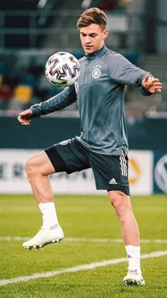 a man kicking a soccer ball on top of a field