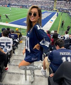 a woman sitting on the bleachers at a football game