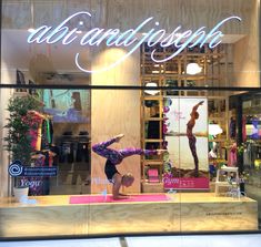 a store front window with a woman doing a handstand