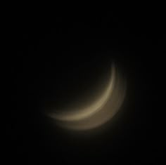 the moon is seen in the dark night sky with no light on it, and there are only two visible crescents