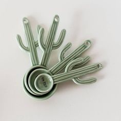 four green utensils are stacked on top of each other in the shape of a cactus