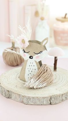 a paper fox sitting on top of a piece of wood next to a candle holder