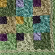 a crocheted blanket with squares on the front and back, in shades of green