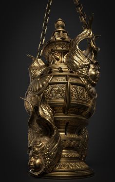 an ornate gold vase with chains hanging from it's sides and two heads on top