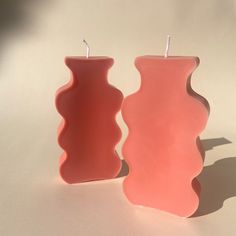 two pink candles sitting next to each other