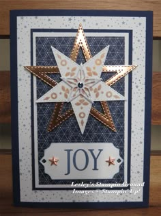 a card with a star on it and the word joy written in gold, white and blue