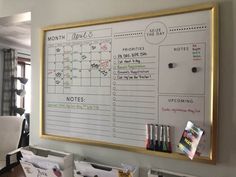 a dry erase board mounted to the side of a wall with calendars on it