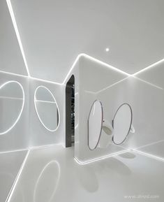 there are three mirrors on the wall in this white room, and one is open