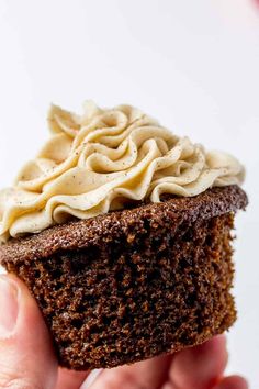 a hand holding up a chocolate cupcake with white frosting on top and the words gingerbread cupcakes above it