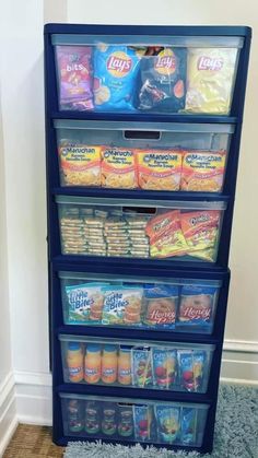 a blue shelf filled with food on top of carpeted floor next to white wall