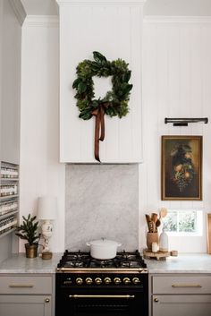 a kitchen with a wreath on the wall above an oven and counter top, along with other items