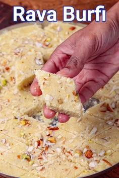 a hand holding a piece of food over a pan filled with rice and other ingredients