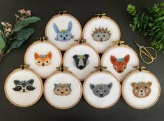 a bunch of embroidered animals are sitting on a table next to some scissors and flowers