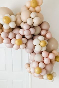 a bunch of balloons that are hanging from the side of a wall in front of a door