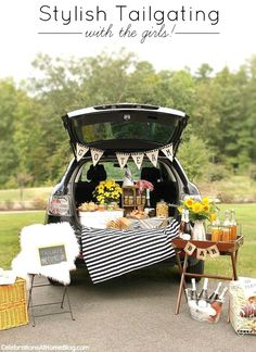 a car with its trunk open and food on the table in it's trunk