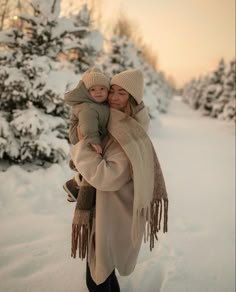 a woman holding a child in the snow