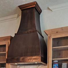 a stove top oven sitting inside of a kitchen next to wooden cabinets and cupboards