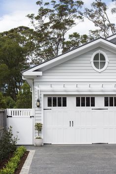 a white house with two garage doors and windows