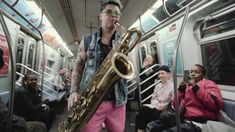 a man playing a saxophone on a subway train