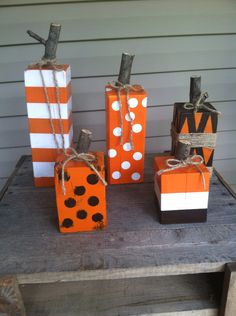 three orange and white boxes tied with twine on top of a wooden table in front of a house