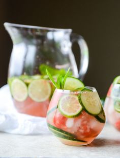 two glasses filled with watermelon and cucumber on top of a table