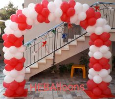 red, white and blue balloon arch with stairs in the background for an entrance to a home