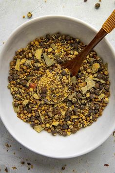 a white bowl filled with lots of food and a wooden spoon sitting in the middle