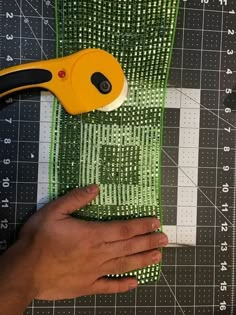 someone cutting fabric with a pair of scissors on top of it and measuring the length