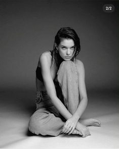 a black and white photo of a woman sitting on the floor