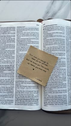 an open book with a piece of paper attached to it