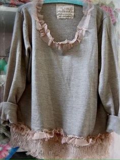 a gray sweater with ruffles on it