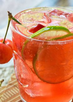 a drink with cherries and lime garnish on the rim