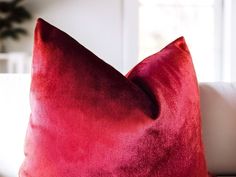 a red pillow sitting on top of a white couch