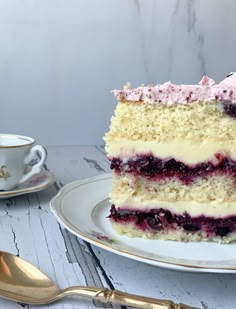 a piece of cake on a plate with a fork next to it and a cup in the background