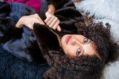 a woman laying on top of a fluffy blanket