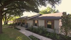 a house with trees and plants in the front yard