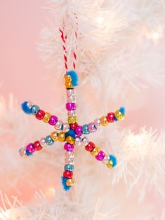 a christmas ornament hanging from the side of a white tree with candy canes