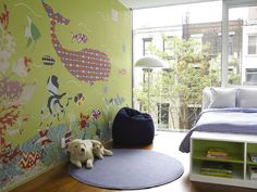 a child's bedroom with green wallpaper and blue rugs on the floor