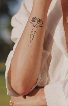 a woman with a flower tattoo on her arm