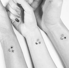 three people with matching wrist tattoos on their arms, one holding the other's hand