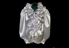 "Elevate your wardrobe with this sophisticated white satin blouse featuring intricate ruffles and puffy sleeves. The luxurious satin fabric excudes elegance, while the carefully designed ruffles add a touch of femininity. Closure with zipper at front.  You can choose between black trimming of the ruffles ( like on the photos ) or whole white. SIZE S - US 6, UK 8, EU 36 bust: bust around 34.5\"/90cm Waist: waist around 27.5\"/70cm Hips: hips around 34.5\"/90cm SIZE M - US 8, UK 10, EU 38 bust: bust around 37.5\"/95cm Waist: waist around 29.5\"/75cm Hips: hips around 37.5\"/95cm SIZE L - US 10, UK 12, EU 40 bust: bust around 39.5\"/100cm Waist: waist around 31.5\"/80cm Hips: hips around 39.5\"/100cm SIZE XL - US 12, UK 14 , EU42 bust: bust around 41.5\"/105cm Waist: waist around 33.5\"/85cm Elegant Blouse With Ruffles And Ruffled Collar, Elegant White Ruffled Tops, Fitted Satin Top With Ruffles, Elegant Ruffle Sleeve Evening Blouse, Elegant Evening Blouse With Ruffle Sleeves, White Ruffled Evening Top, Elegant Satin Tops With Ruffles, Elegant Satin Ruffled Tops, Ruffle Sleeve Blouse With Ruffles For Parties