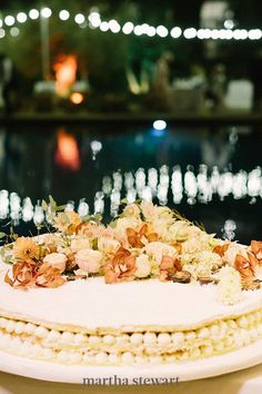 a white cake with flowers on it sitting on a table