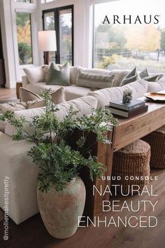 a living room filled with furniture and a plant in a vase on the coffee table