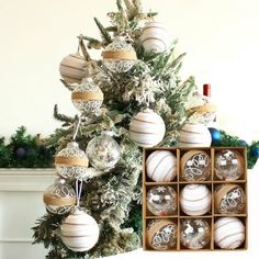 a white christmas tree with ornaments in wooden boxes