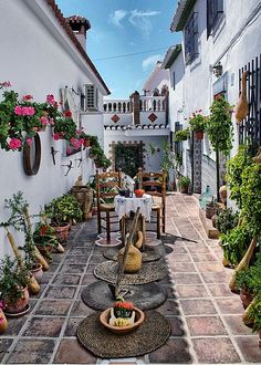 an outdoor patio with potted plants and tables