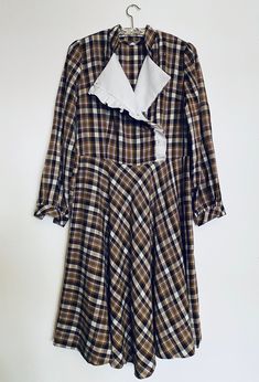 "This is a super fabulous vintage 70's brown check prairie dress with bib and white ruffles detailing, puff sleeves and a full skirt, this dress is in very good vintage condition. Size: 38/ 10/M All garments are worn but in a good vintage condition, there may be small signs of wear or very minor flaws that are due to come with the items age but any more serious flaws that we find have been pictured. We do not except any returns for any sizing issues since we provide measurements, make sure to check them carefully and please ask for any extra information you might need that not be provided already, we measure our garment flat from side to side, armpit to armpit, hip to hip... so bust, hip and waist measurements need to be doubled. Measurements: Shoulders; 36cm/ 14\" Bust; 48cm/ 19\" Waist; Fall Prairie Dress With Ruffles, Retro Ruffled Dresses For Fall, Vintage Plaid Dress For Fall, Fitted Brown Plaid Dress For Spring, Retro Vintage Dress With Ruffles For Fall, Vintage Ruffled Dress For Fall, Retro Plaid Dresses With Ruffles, Retro Plaid Dress With Ruffles, Retro Brown Dress With Ruffles