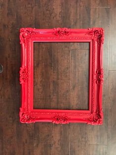 a red frame sitting on top of a wooden floor