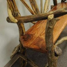 a wooden bench made out of branches on the floor next to a carpeted area